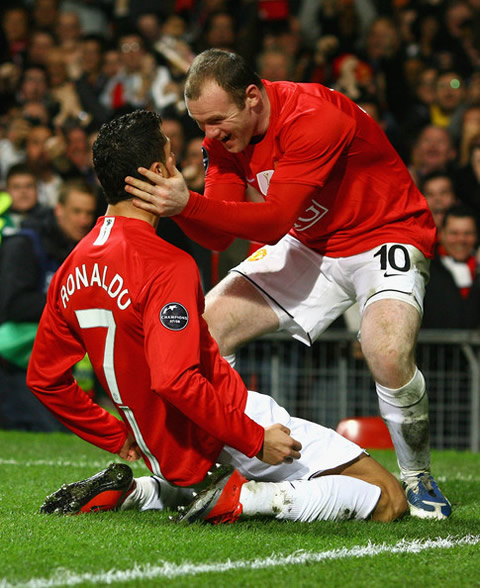 Wayne Rooney with his hands on Cristiano Ronaldo face in a knee sliding celebration in Manchester United