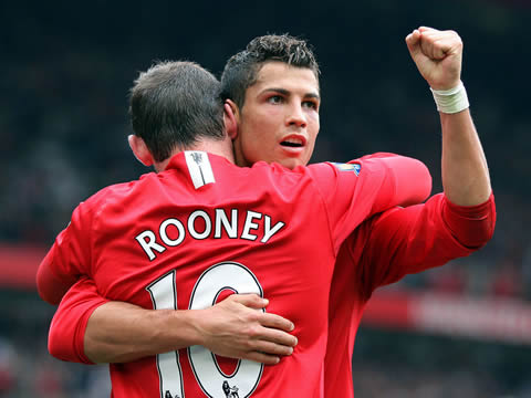 Wayne Rooney and Cristiano Ronaldo huggind each other with Ronaldo raising his left hand