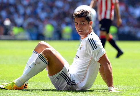 Cristiano Ronaldo looking afraid as he turns around while seated on the ground