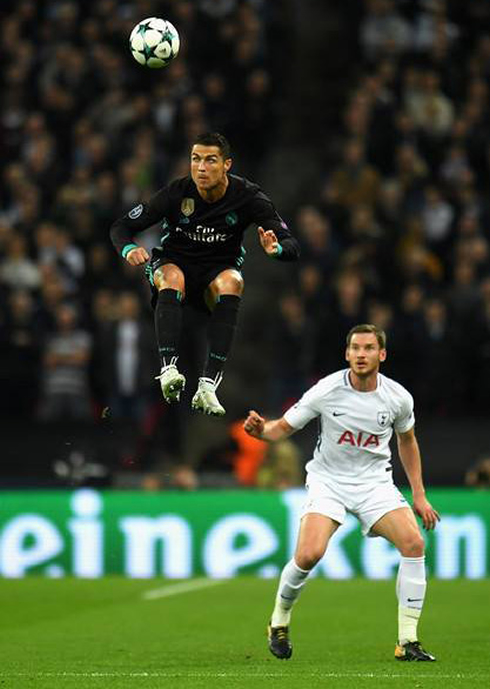 Cristiano Ronaldo jumps high in the air to head a ball, in Tottenham vs Real Madrid