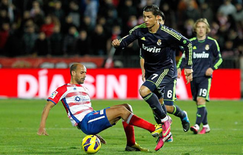 Cristiano Ronaldo getting past a Granada defender, but being tackled as he prepares to sprint