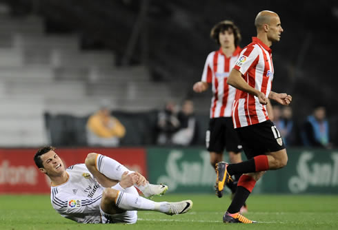 Cristiano Ronaldo holding on to his left leg, after having been tackled