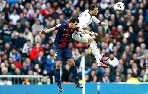 Cristiano Ronaldo jumping higher than Sergio Busquets, in Real Madrid vs Barcelona, for La Liga 2013