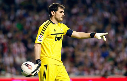 Iker Casillas in a yellow uniform and holding the ball as if it was glewed to his hand, in a game for Real Madrid in 2012