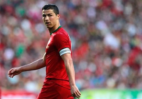 Cristiano Ronaldo playing for Portugal and looking above his shoulder while he puts his tongue out, in 2012