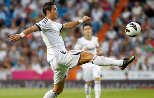 Cristiano Ronaldo stretching himself to reach a ball and receive it, in a Real Madrid game for La Liga 2012/13