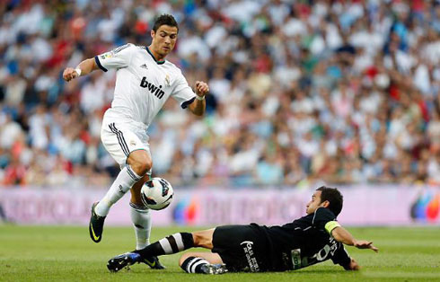 Cristiano Ronaldo dribbling a defender from Granada, in a game for Real Madrid in La Liga 2012