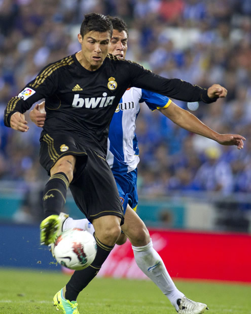 Cristiano Ronaldo controling the ball while being chased by a defender