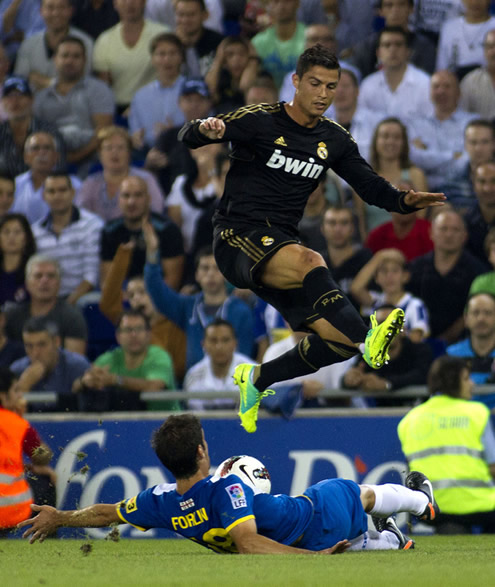 Cristiano Ronaldo with his new Nike Mercury boots and cleats, jumping over a defender