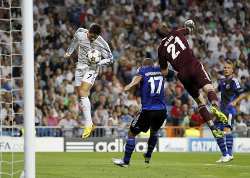Cristiano Ronaldo jumping higher than a defender and a goalkeeper to score a goal in Real Madrid vs Copenhagen, in 2013-2014