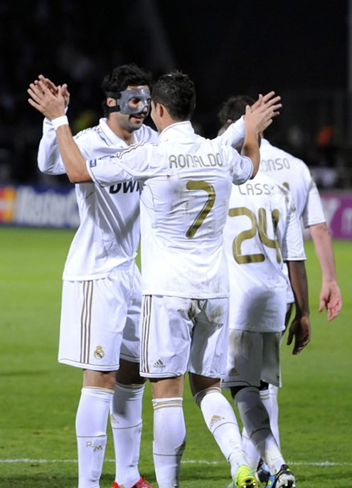 Cristiano Ronaldo touches hands with Raul Albiol, using a mask-face