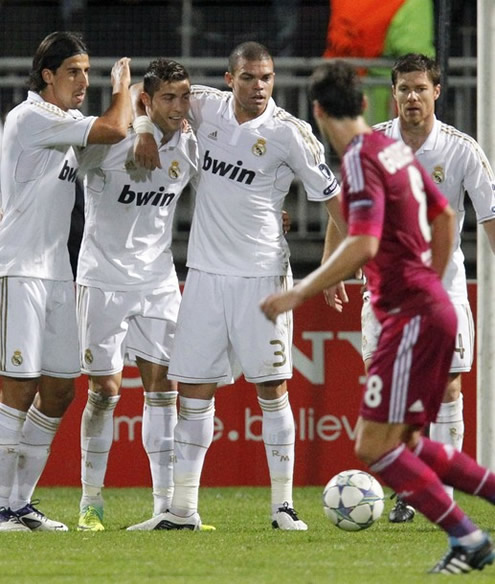 Pepe puts his arm around Cristiano Ronaldo, while Khedira taps him and Xabi Alonso walks near them