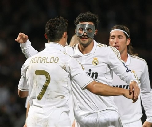 Cristiano Ronaldo prepares to hug Raul Albiol, who was using a mask on his face