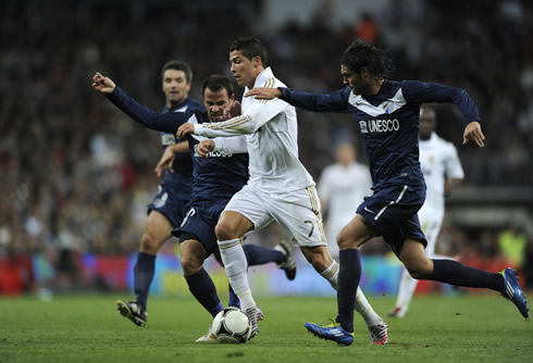 Cristiano Ronaldo getting past two defenders in Real Madrid vs Malaga, in the Santiago Bernabéu 2011-2012