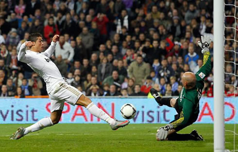 Cristiano Ronaldo attempting to reach the ball before Malaga goalkeeper