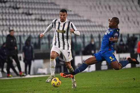 Cristiano Ronaldo tries to avoid a strong tackle from a Udinese defender
