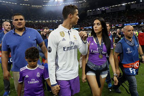Cristiano Ronaldo holding his son's hand and walking next to his girlfriend Georgina Rodriguez
