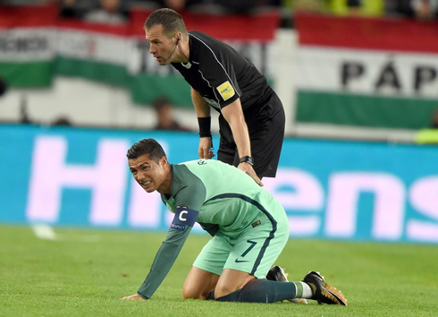 The referee gives Cristiano Ronaldo a hand to help him getting up