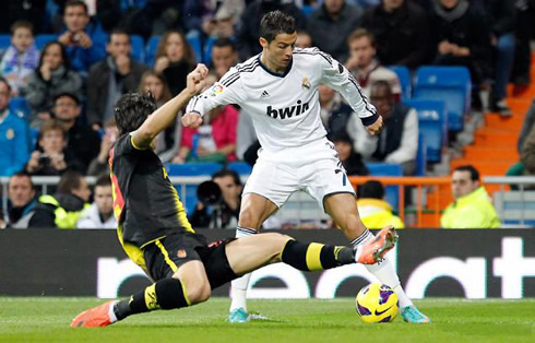 Cristiano Ronaldo tricking a defender and sending him to the ground, before making a cross during a match for Real Madrid in 2012-2013