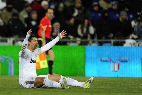 Cristiano Ronaldo opens his arms while sitted on the ground, in a La Liga match in 2012