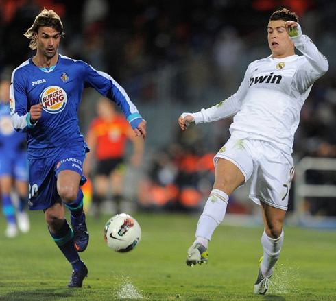 Cristiano Ronaldo making the first touch with the ball, with a close guard by a Getafe defender