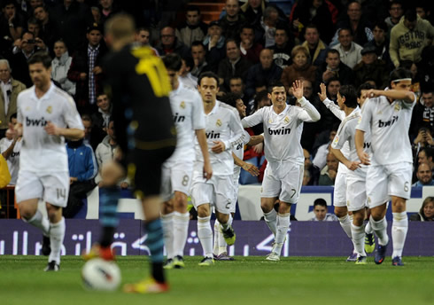 Real Madrid players returning to their midfield, while Ronaldo still celebrates with Ozil far away