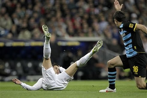 Cristiano Ronaldo with his back against the ground, as an Espanyol defender tells him to get stand up