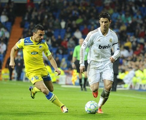 Cristiano Ronaldo sprinting side-by-side with an APOEL defender, in the UCL 2012