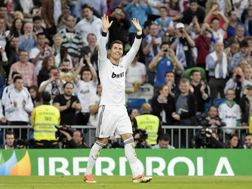 Cristiano Ronaldo raising his two hands in the air to wave to his family in the Santiago Bernabéu stands, in 2013