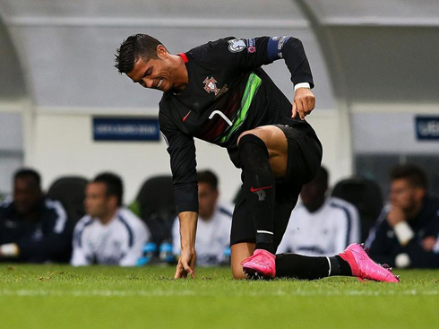 Cristiano Ronaldo trying to get up as he puts one knee on the ground