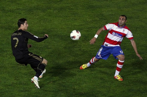 Cristiano Ronaldo losing balance when trying to reach a ball, with Carlos Martins from Granada, in La Liga 2012