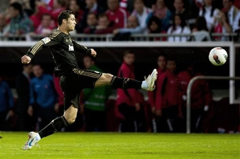 Cristiano Ronaldo stretching his right leg attempting to reach the ball, in Real Madrid 2012