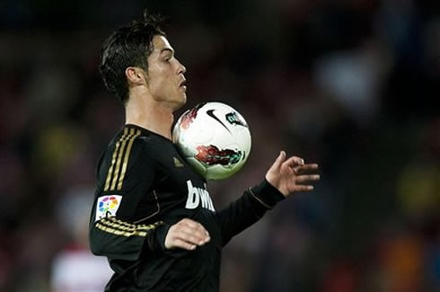 Cristiano Ronaldo receiving the ball on his chest, while wearing Real Madrid's black jersey in 2012