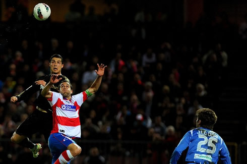 Cristiano Ronaldo raising above the defender after jumping to head a ball
