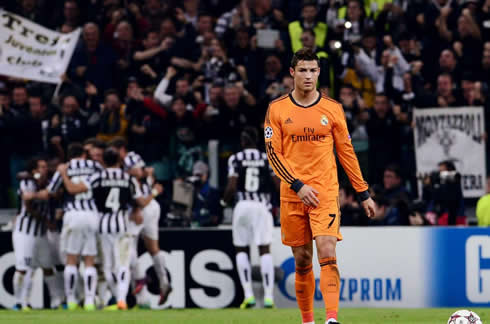 Cristiano Ronaldo walking back to Real Madrid half, as Juventus players celebrate in the background