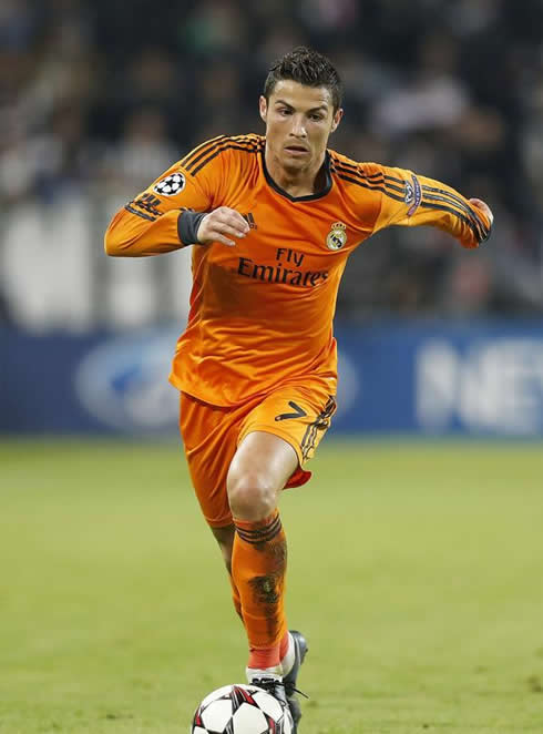 Cristiano Ronaldo playing in a Real Madrid orange jersey 2013-2014