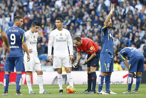 Cristiano Ronaldo awaits for the referee to put on the spray to mark the pitch