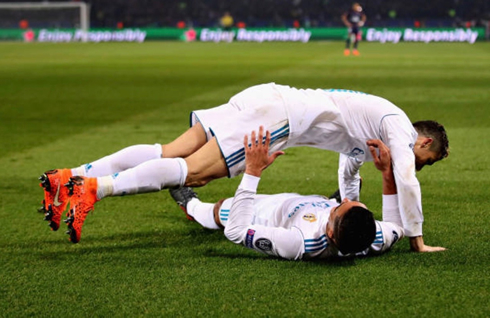 Cristiano Ronaldo lying down over Lucas Vázquez after his assist for his header goal in Paris