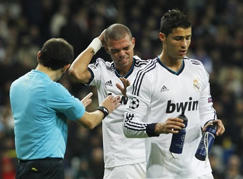 Cristiano Ronaldo holding two water bottles, while Pepe complains about his head, in a Champions League clash between Real Madrid and Borussia Dortmund, in 2012-2013