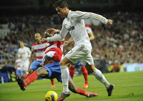 Cristiano Ronaldo tries to avoid a bad tackle from a Granada defender