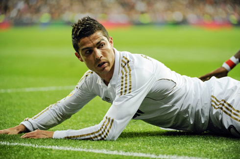 Cristiano Ronaldo layed on the ground and looking at someone above his shoulders