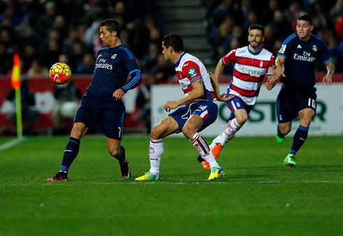 Cristiano Ronaldo protecting the ball as James runs behind him