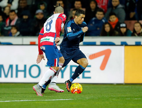 Cristiano Ronaldo trying to run away from a Granada defender