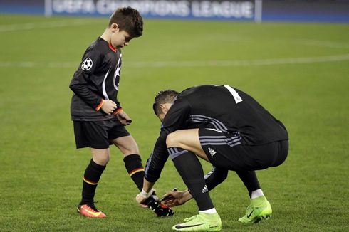 Cristiano Ronaldo writes down his signature on a kid's boots before a Champions League game in Italy