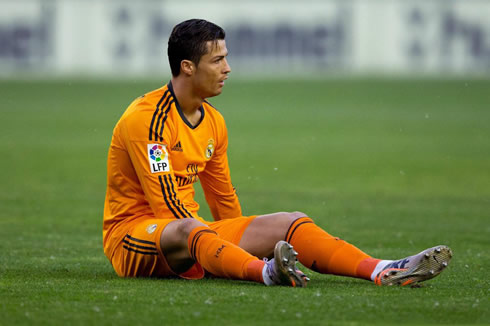Cristiano Ronaldo sits on the pitch holding his left thigh, concerned about having aggravated his injury against Valladolid