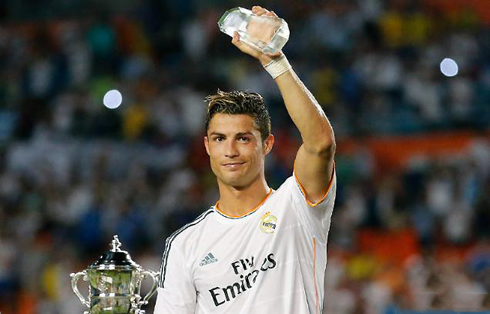 Cristiano Ronaldo holding the MVP trophy and the Guinness International Champions Cup on his hands, in 2013