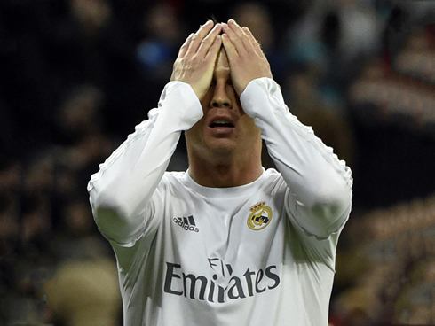 Cristiano Ronaldo covers his face with his hands in frustration