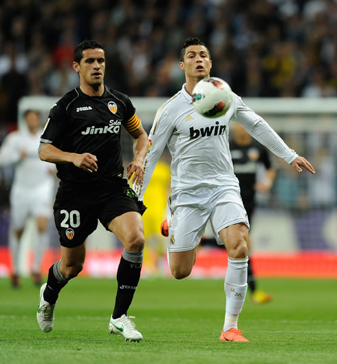 Cristiano Ronaldo chasing the ball side by side with Valencia captain, Ricardo Costa, in a Real Madrid game in 2012
