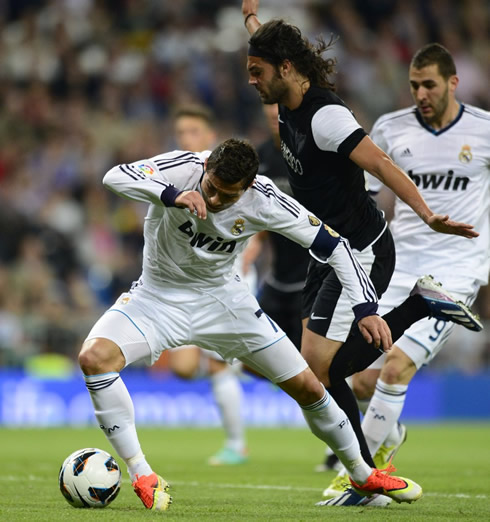 Cristiano Ronaldo being charged inside Malaga's penalty area, in a home game for Real Madrid in La Liga 2013