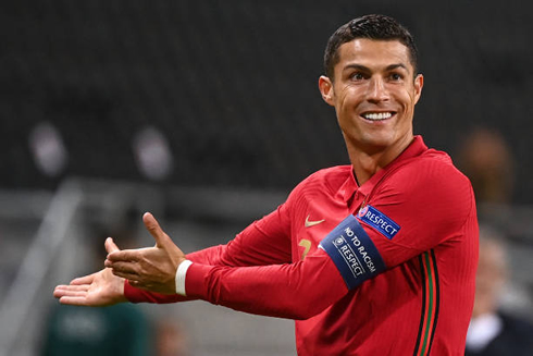 Cristiano Ronaldo smiling and pointing to his right